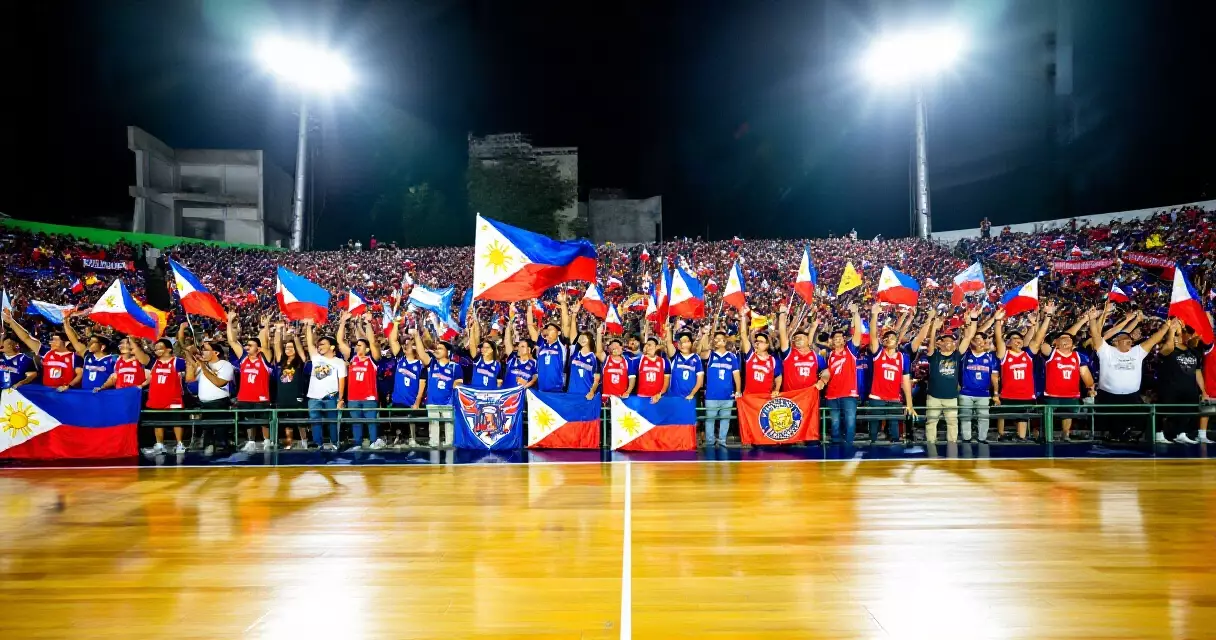 Mga Pilipinong tagahanga ng basketball sa isang malaking arena, nagwawagayway ng mga banner