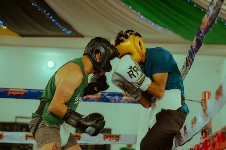 Two boxers engaged in a thrilling match wearing protective headgear and gloves.